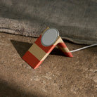 Wireless charging stand with a striped design on a textured surface