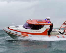 Speedboat on water with a person standing on the deck