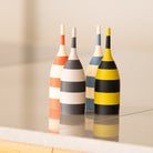 Four striped toothpick dispensers on a reflective surface with a neutral background